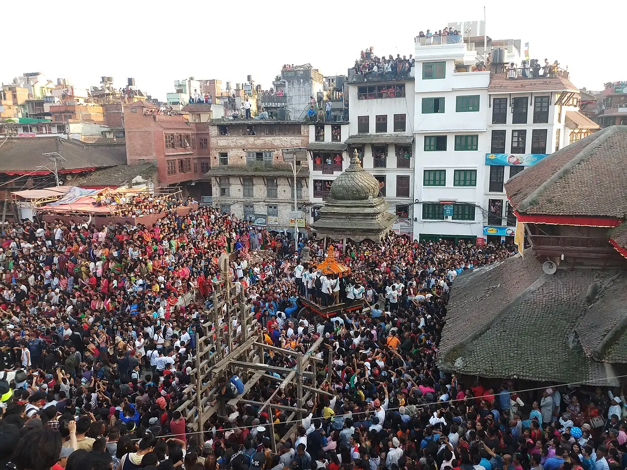 Multidão compacta lotando a Praça Durbar de Katmandu, com templos em pagode ao redor, durante a procissão do carro no Indra Jatra.