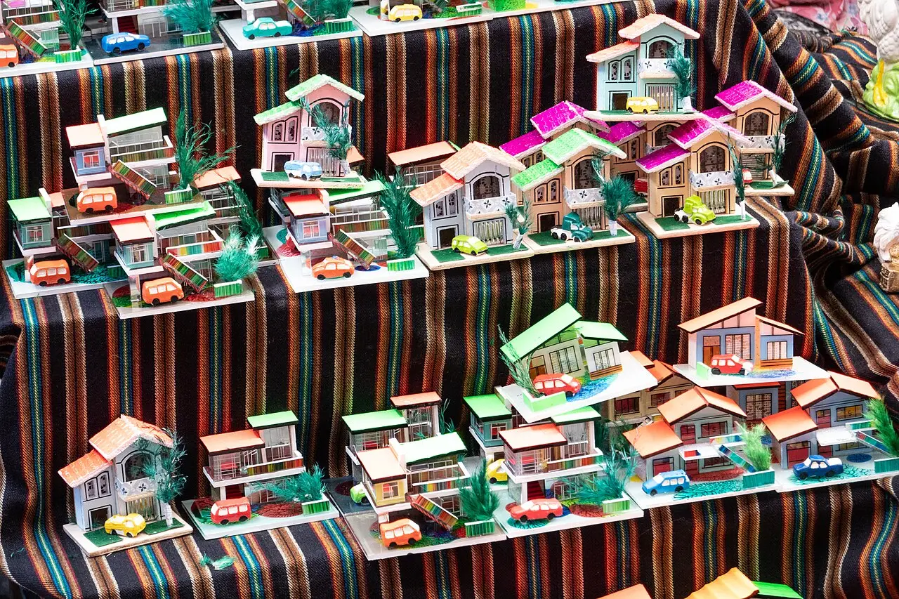 Casinhas em miniatura coloridas dispostas sobre um pano listrado numa banca da Feria de las Alasitas, em La Paz.