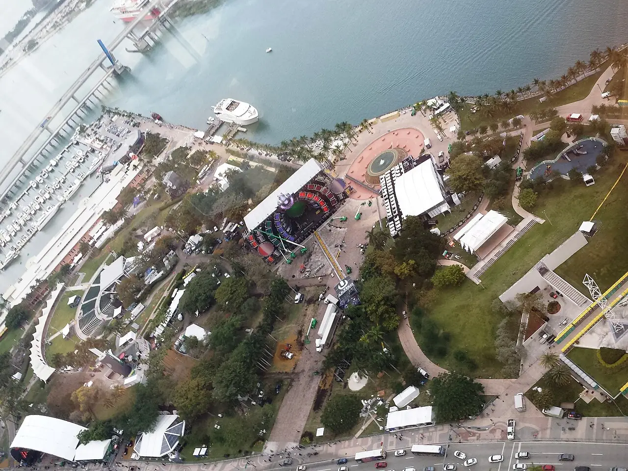 Visto desde arriba, el parque junto al agua tiene un escenario cubierto, carpas blancas y caminos en el césped.