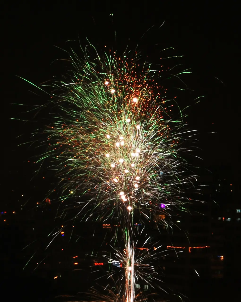 Fogos de artifício vermelhos, verdes e dourados se abrem no céu escuro durante o Diwali em Mumbai.