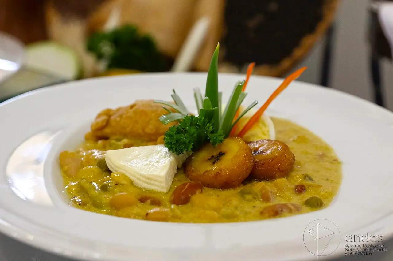 Prato de fanesca amarela, servido com queijo, folhas verdes e guarnições, no encontro de fanescas de Quito em abril de 2017.