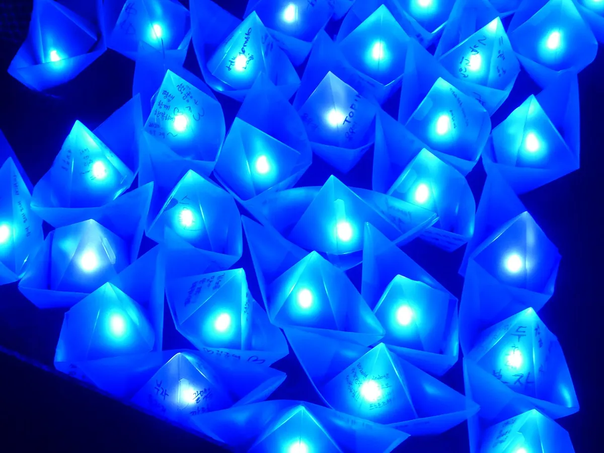 Lanternas de papel em forma de barco, acesas em azul e com votos escritos à mão, no Festival de Lanternas de Seul de 2019.