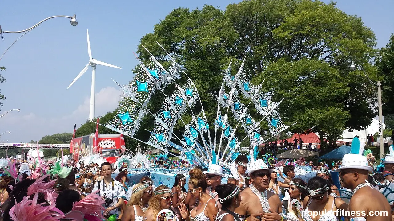 Um enorme leque de penas azuis e brancas se ergue no meio da multidão do desfile.