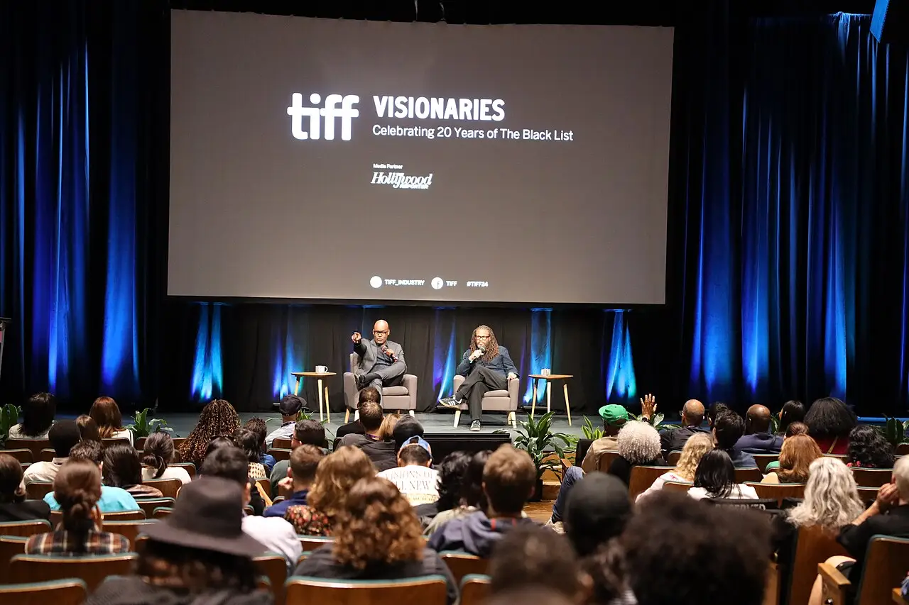 El público mira el escenario, donde dos personas sentadas conversan ante la pantalla tiff Visionaries.