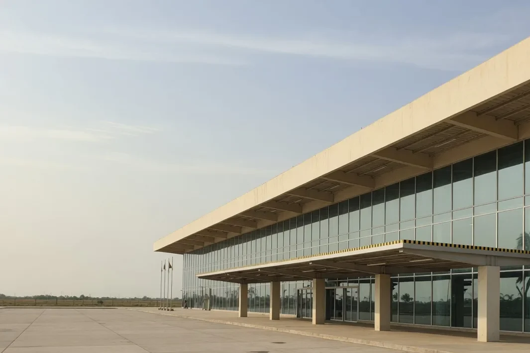 Terminal bas avec une façade vitrée, un auvent et une esplanade vide.