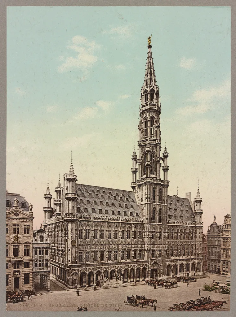 Photochrom colorido do edifício gótico e sua torre alta na praça, com carruagens, pessoas e inscrição junto à borda inferior.