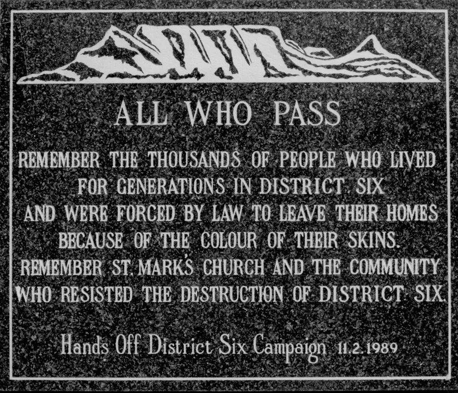 Uma placa de pedra escura com um desenho de montanhas e um texto em inglês.