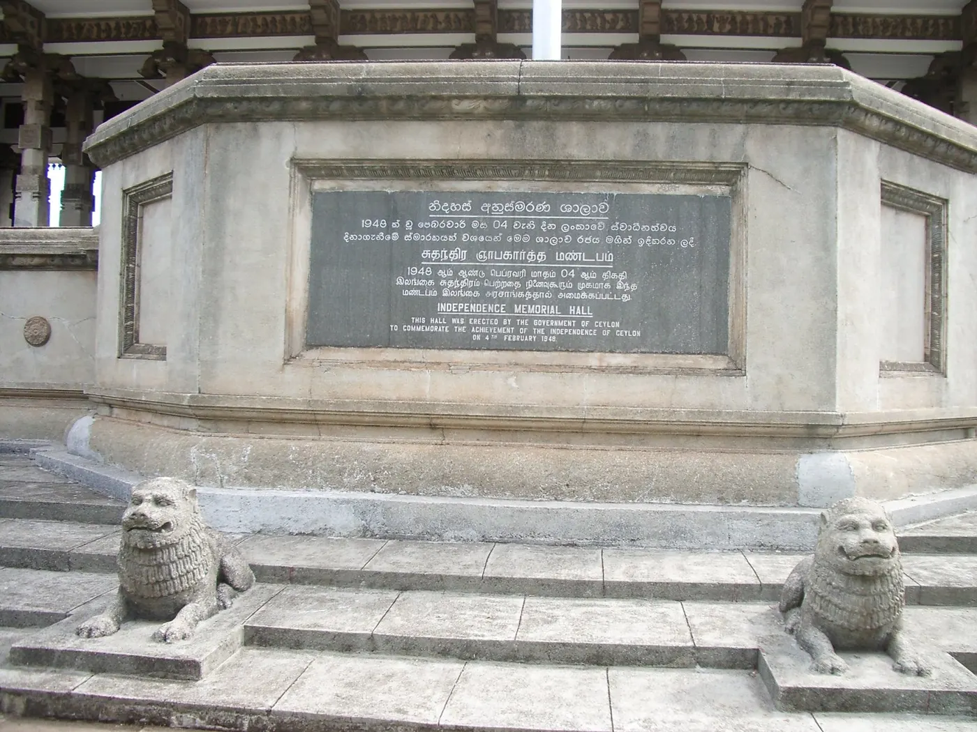 La base en pierre d’un hall, avec une plaque et deux lions de pierre sur les marches, sans personne.