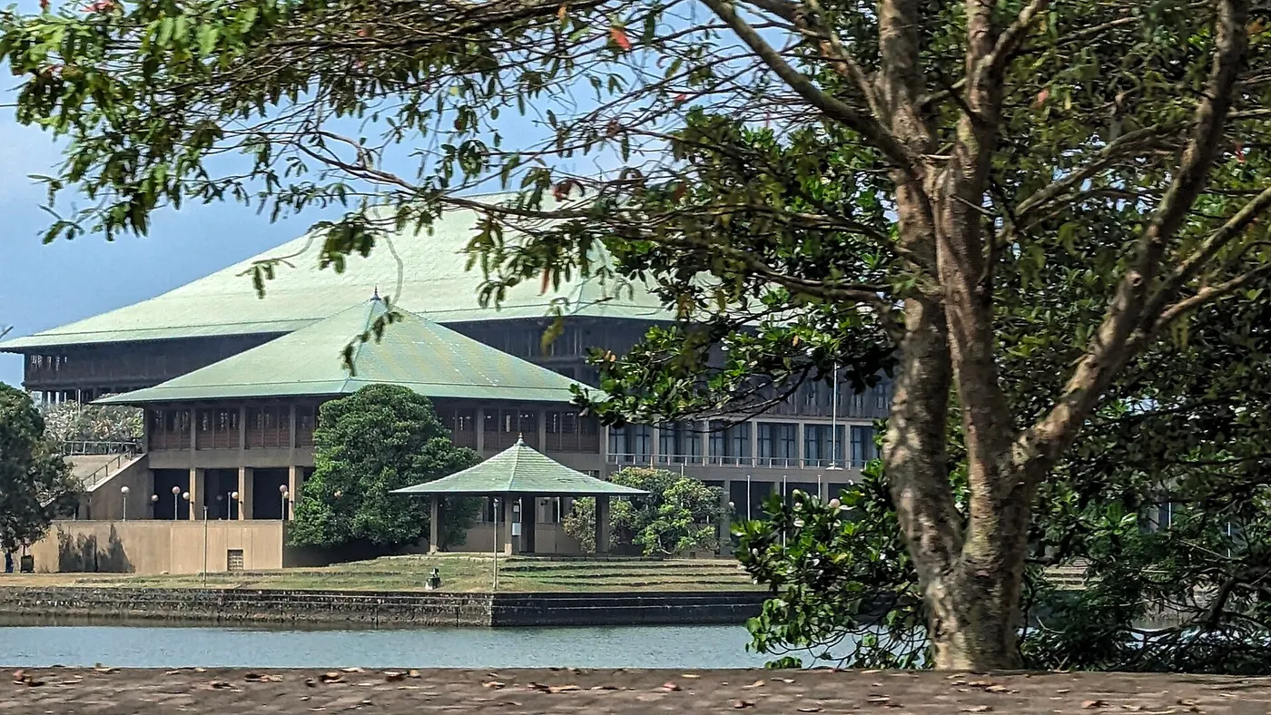 Um edifício de telhados de cobre sobre uma ilha, cercado de água.