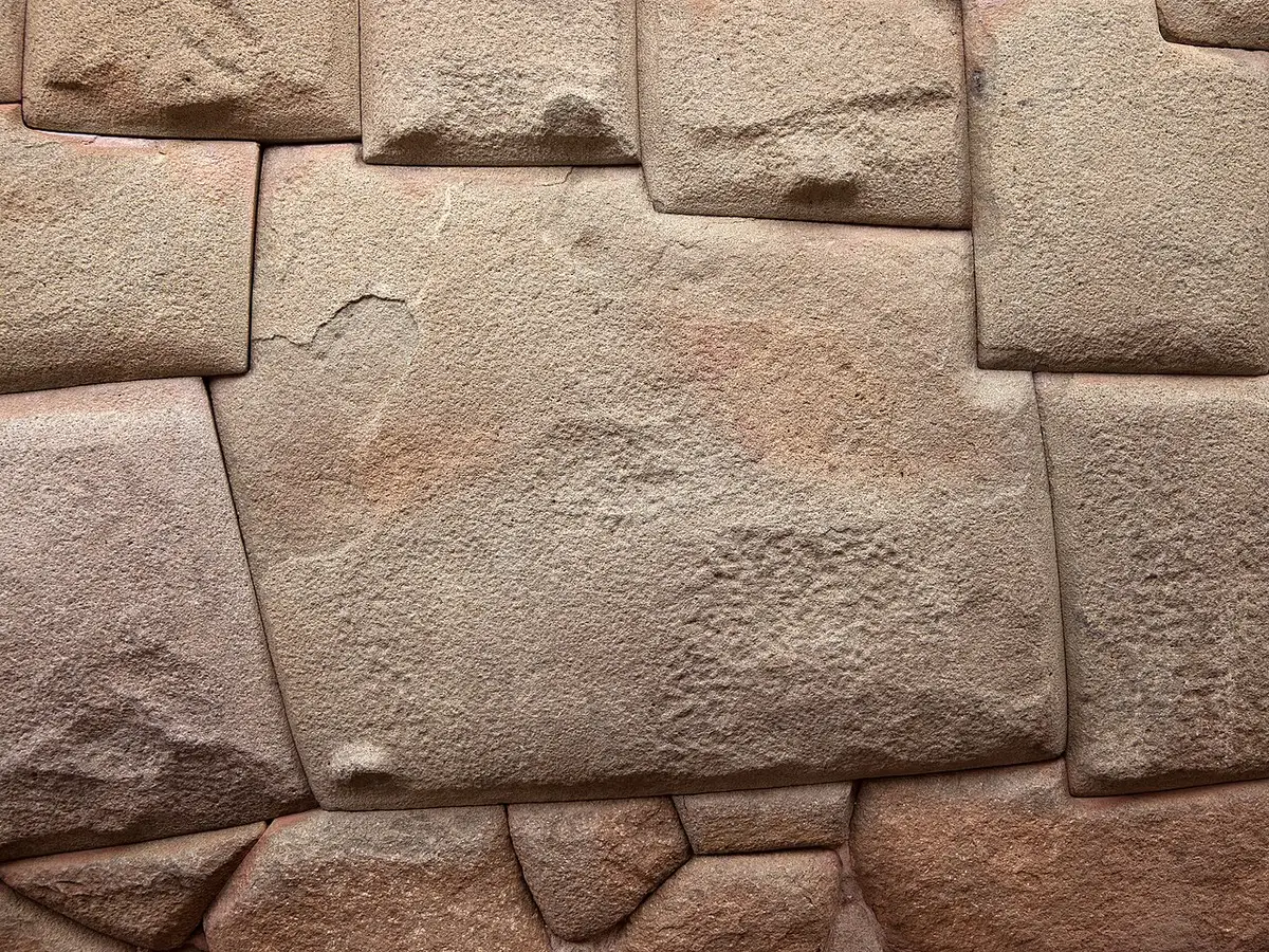 Bloco de pedra de muitos cantos, encaixado sem argamassa nas pedras ao redor.