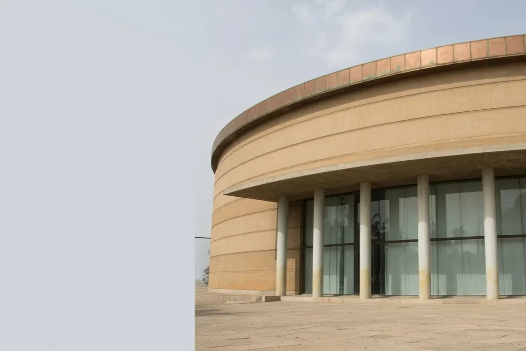 Musée rond à bandes horizontales, avec des colonnes et un grand débord.