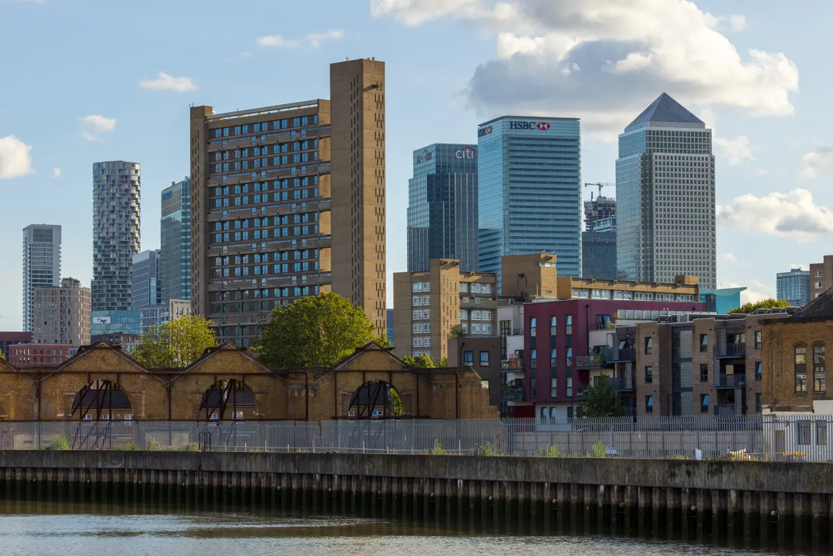 Panorama de Poplar e Canary Wharf, com blocos residenciais, armazéns de tijolo e arranha-céus, incluindo One Canada Square.