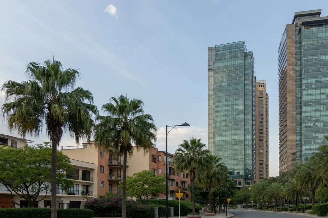 As duas torres de vidro à direita, com o céu azul claro no meio e a rua vazia.