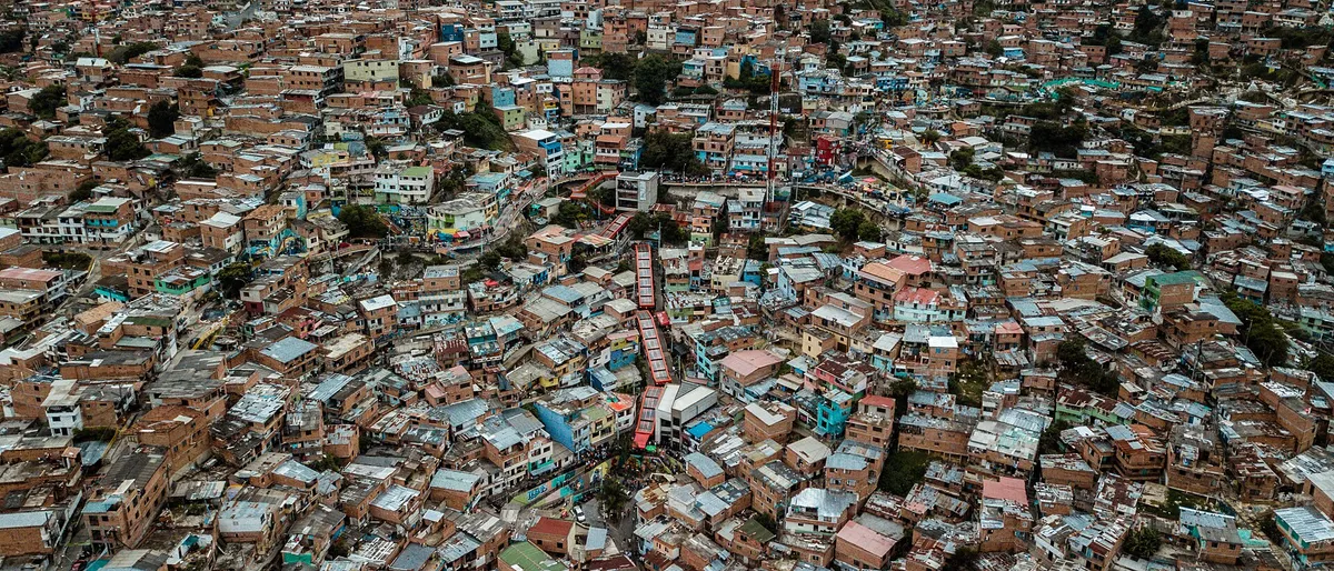 As escadas rolantes vermelhas no meio das casas da encosta da Comuna 13.