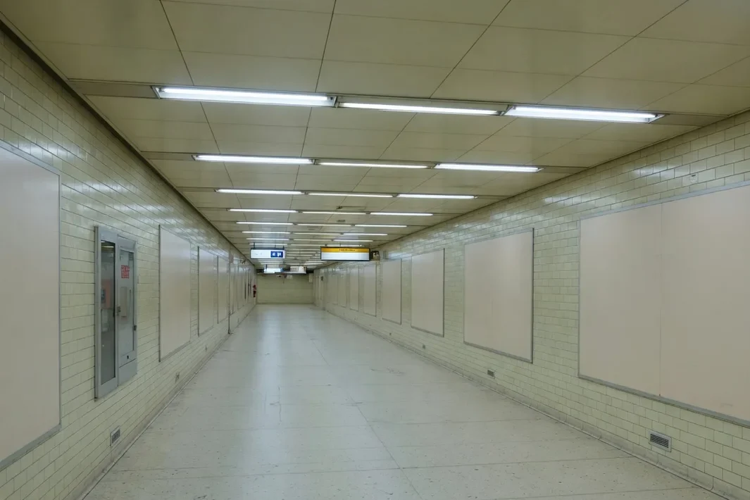 An empty underground walkway, with a pale ceiling and tiled walls.