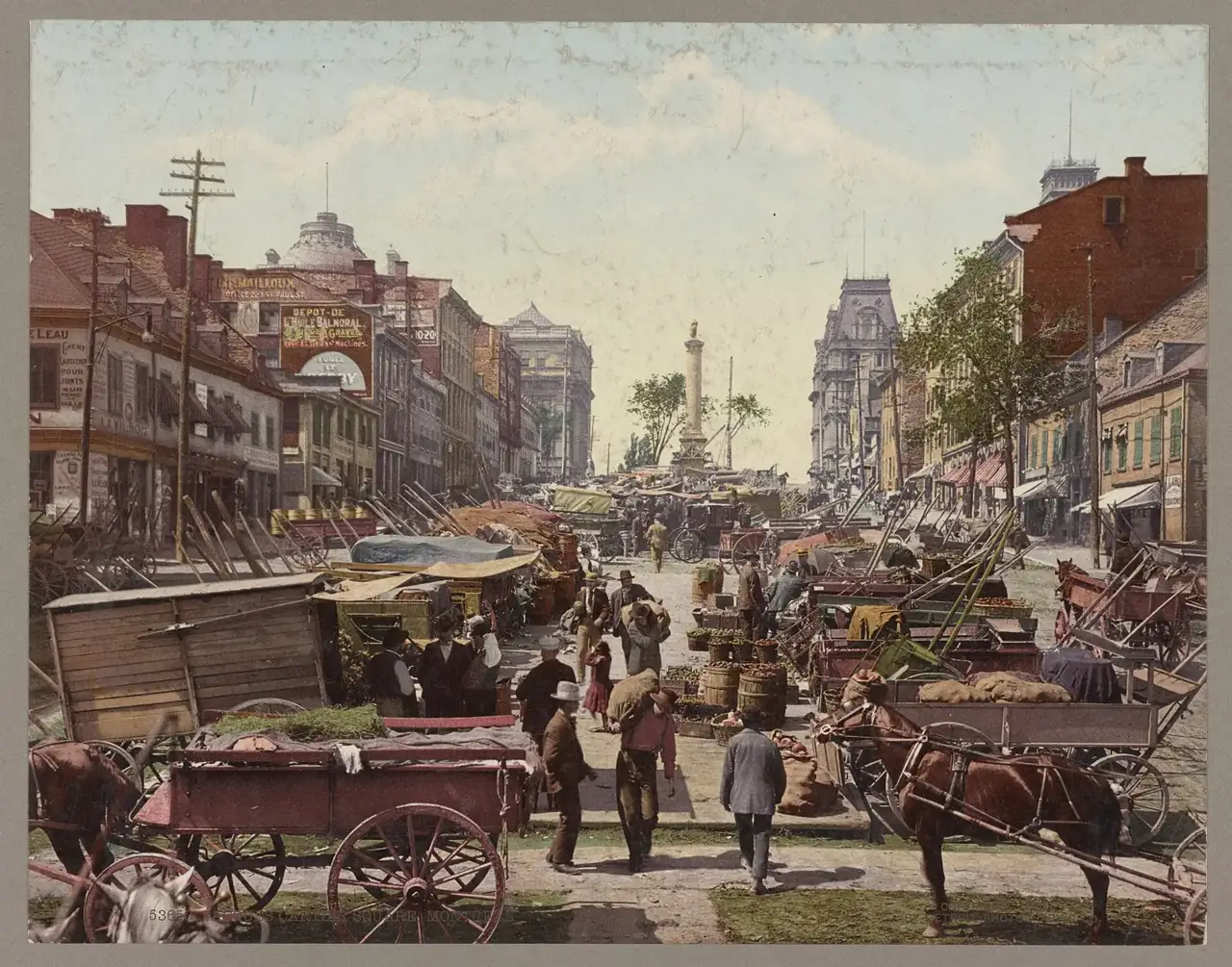 Carroças puxadas por cavalos carregadas de mercadorias na Praça Jacques Cartier, com uma coluna ao centro e prédios comerciais dos dois lados.