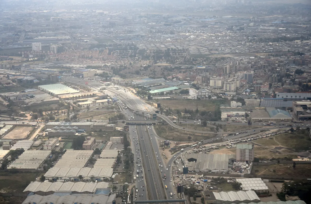 Vista aérea da via expressa elevada e do entroncamento, com a cidade ao fundo.