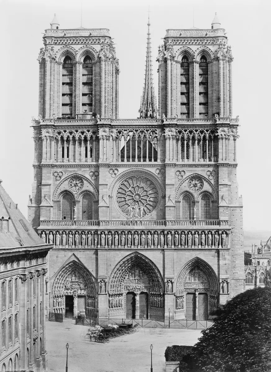 Fachada de Notre-Dame com duas torres, rosácea, portais e carruagens na praça.