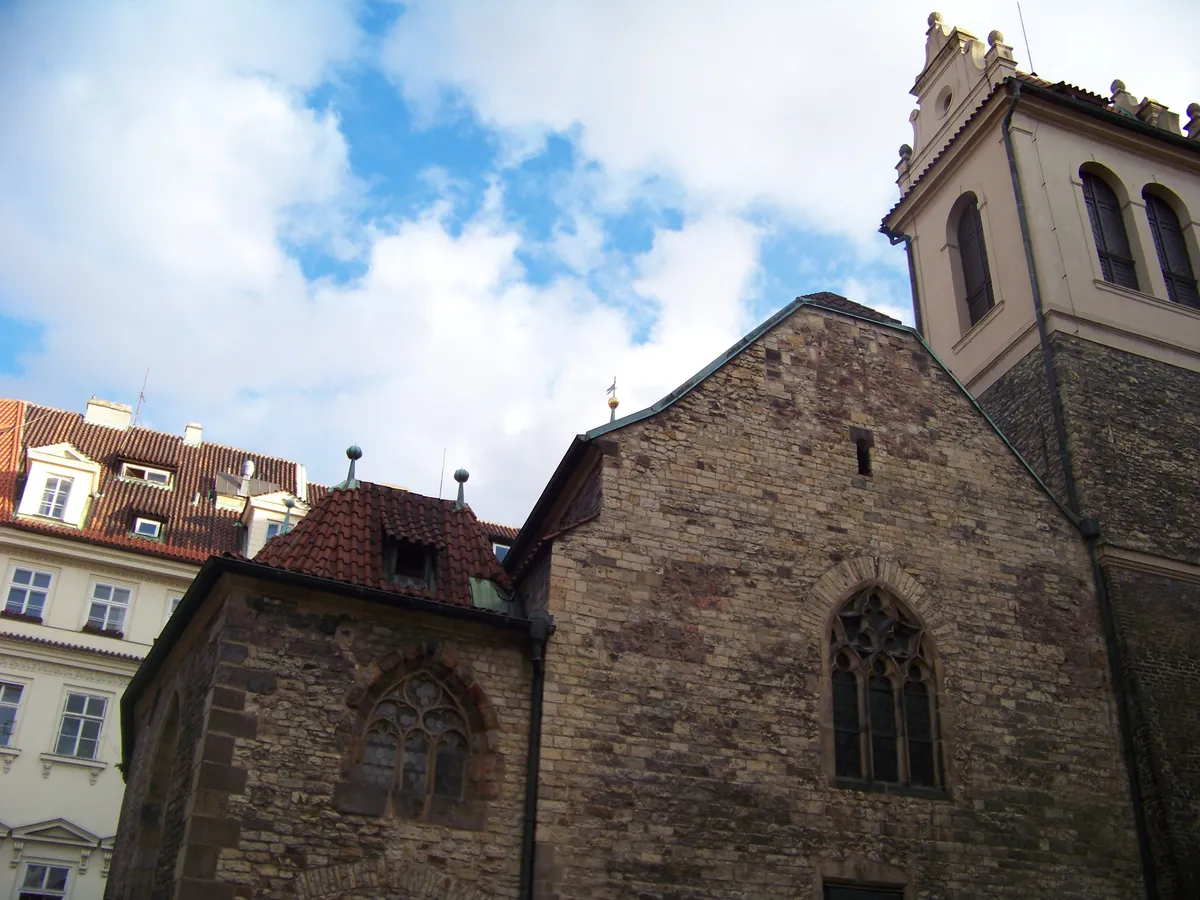Part of the medieval Church of St Martin: stone walls, pointed windows, roof and a partially visible tower against a blue sky.