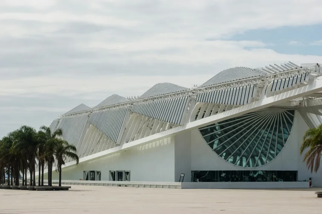 O Museu do Amanhã branco, com o teto em costelas e o leque de vidro, numa praça vazia.