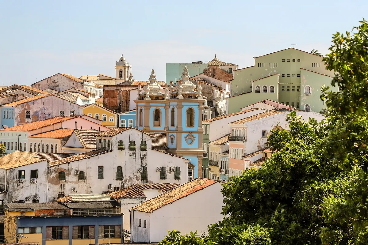 Casas de telhado vermelho e uma torre azul no meio do centro histórico.