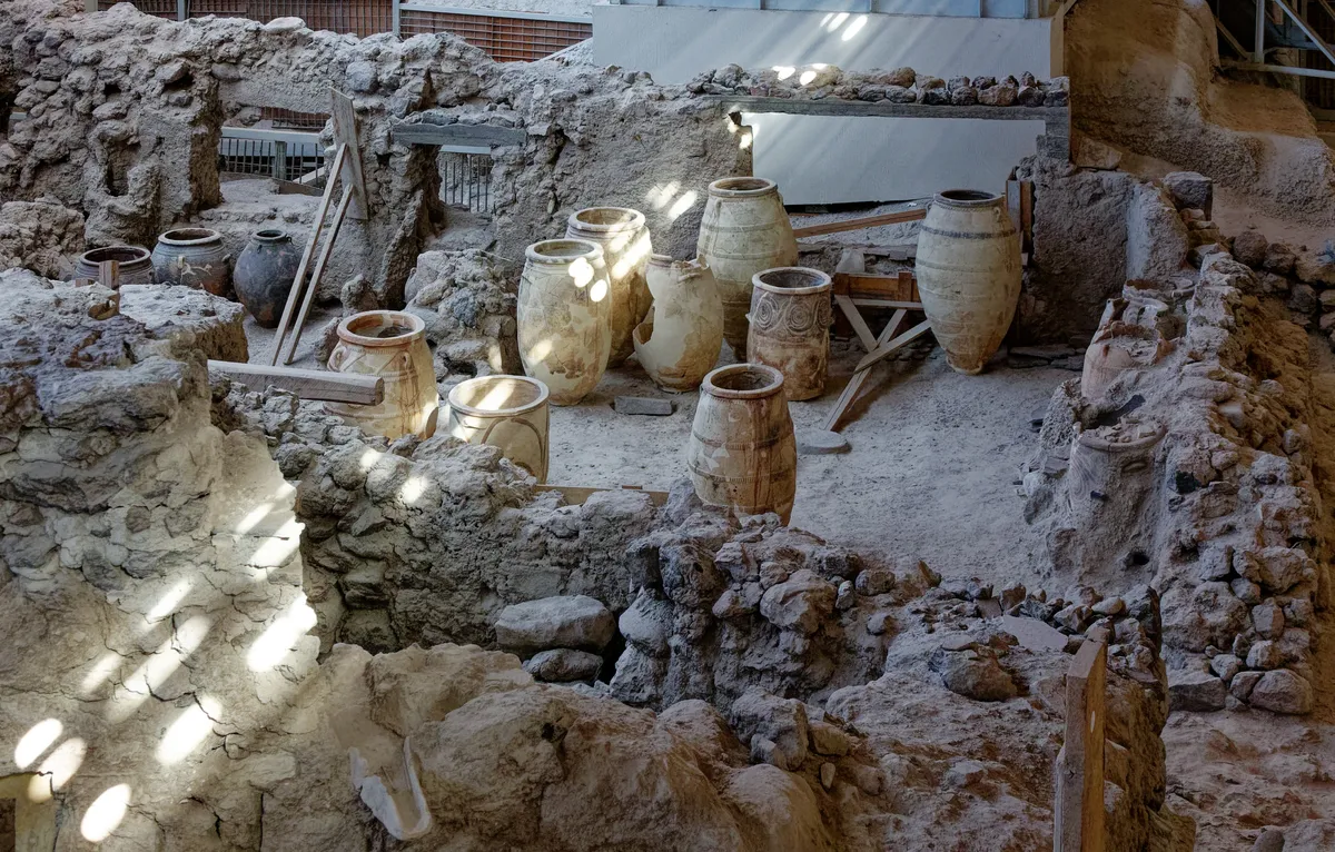 Jarros de cerâmica entre muros de pedra da cidade soterrada.