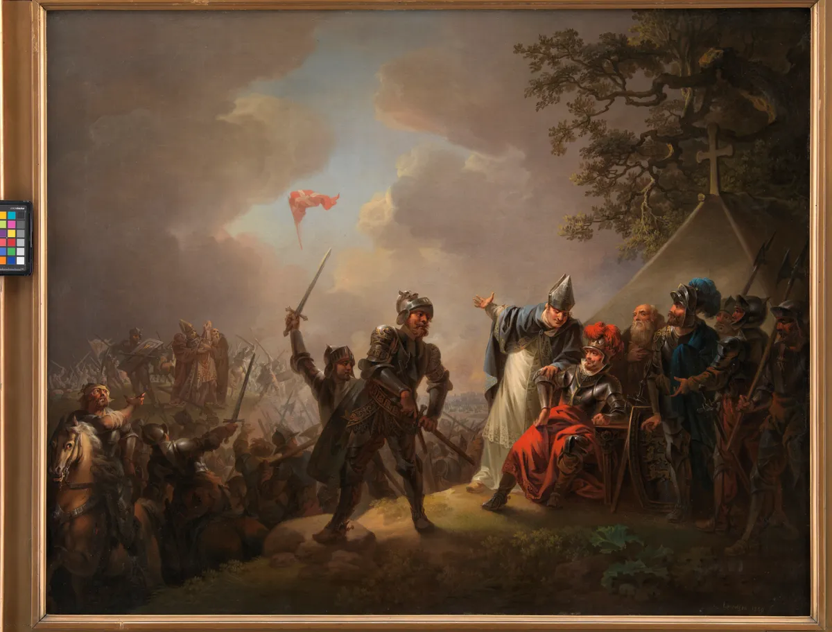 Pintura de batalha com cavaleiros, figuras de armadura, clérigo de braços abertos e bandeira vermelha no céu, dentro de moldura dourada e com escala de cores lateral.