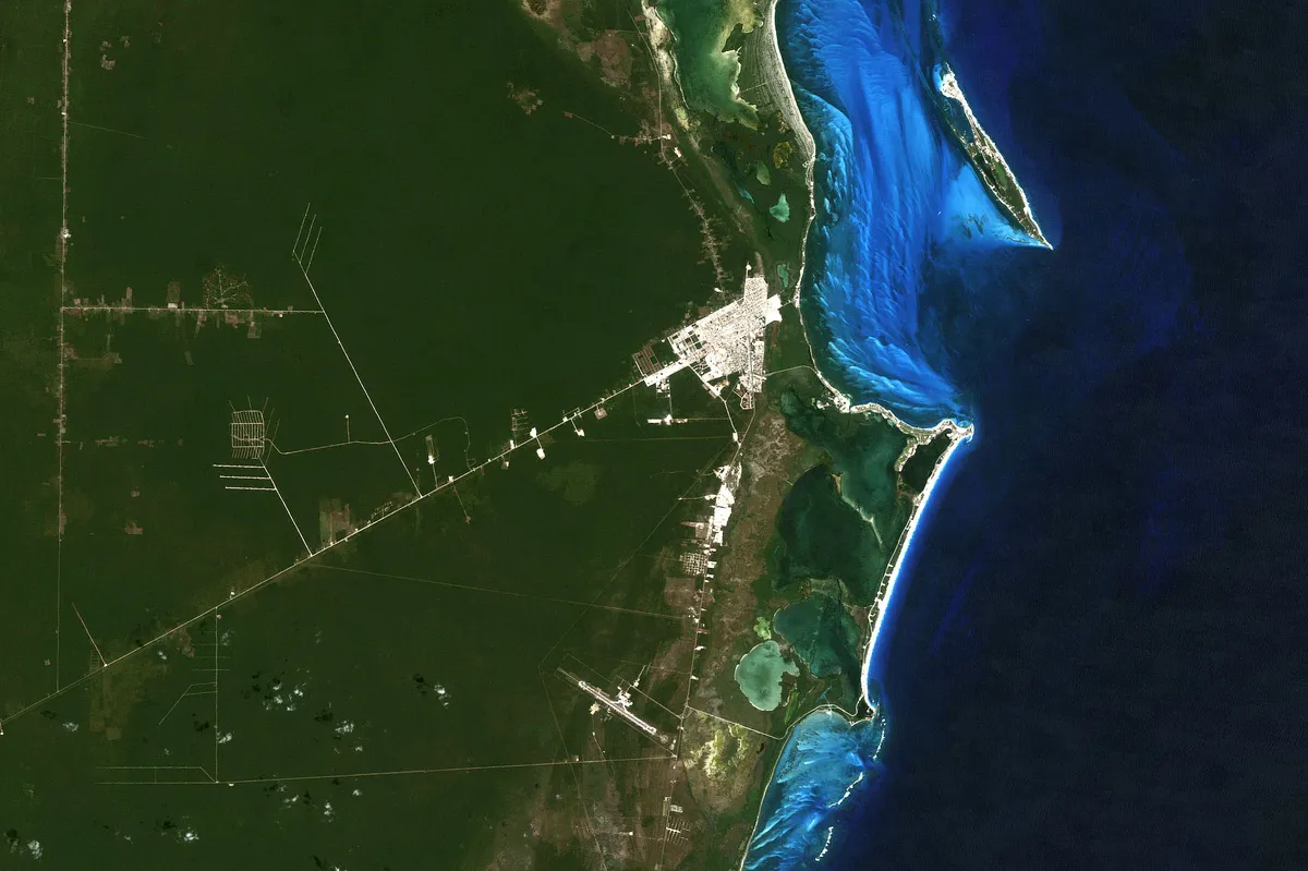 Imagem de satélite de Cancún com a cidade, faixa costeira, lagoas, aeroporto e floresta em 1985.
